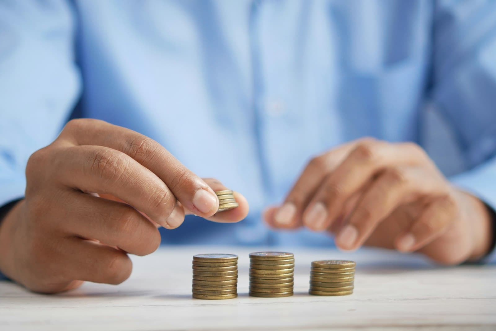 Stacked coins beside a ledger, illustrating broker-dealer financial recordkeeping.